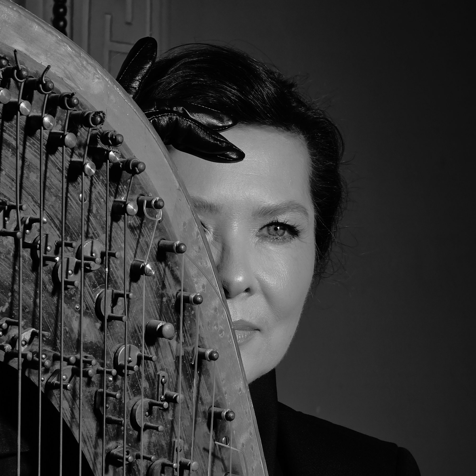 Portrait of the artist beside a piano, dramatic lighting